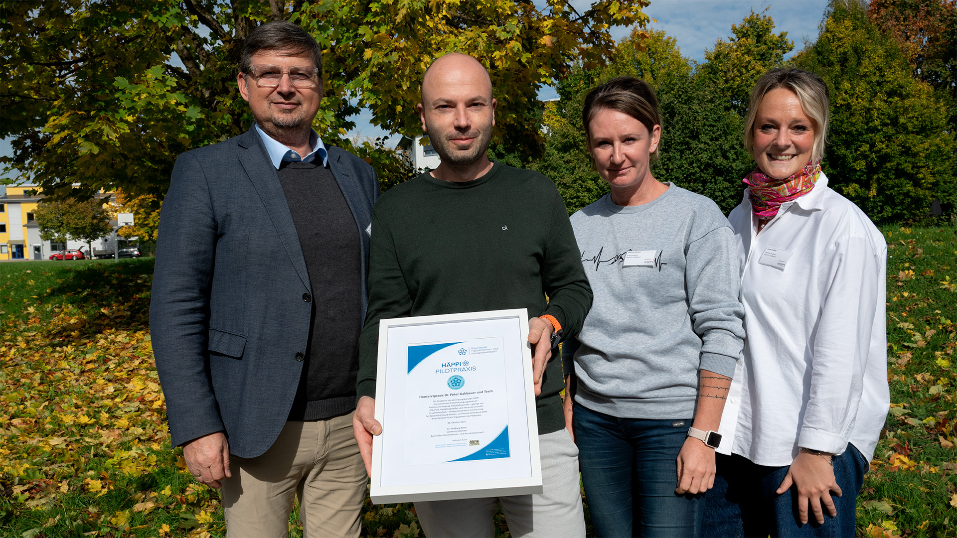 Dr. Peter Gahbauer und sein Team nehmen die Urkunde zur HÄPPI-Pilotpraxis vom Bayerischen Hausärztinnen- und Hausärzteverband entgegen.